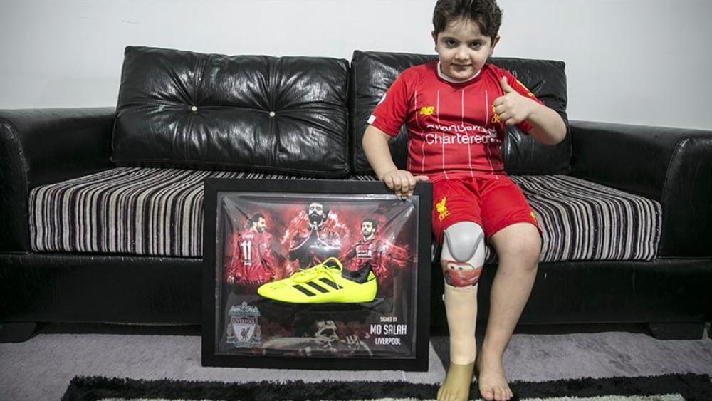 طفل سوري "مبتور الساق" يحصل على قميص وحذاء موقعين من محمد صلاح