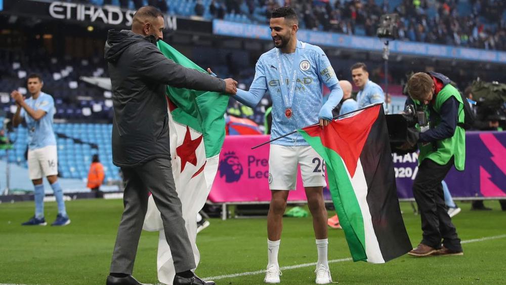 رياض محرز يحتفل بلقب الدوري الإنجليزي الممتاز حاملا علم فلسطين