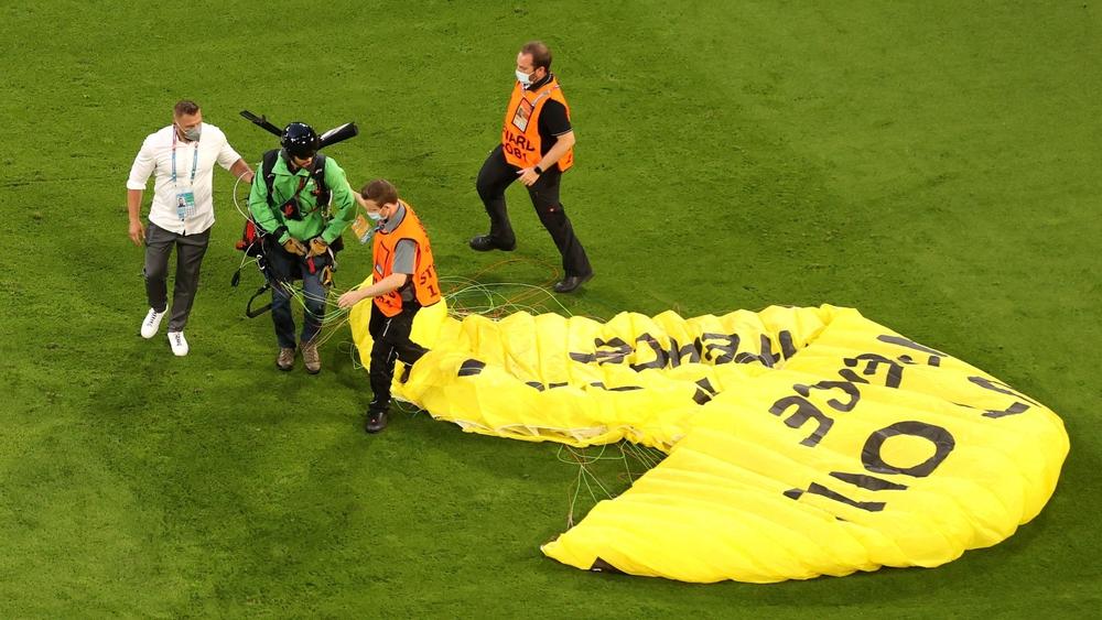 في "لقطة طريفة".. مظلي يحط مُحلِّقاً بأرضية ملعب "أليانز أرينا" قبل بداية مباراة ألمانيا وفرنسا بثوان
