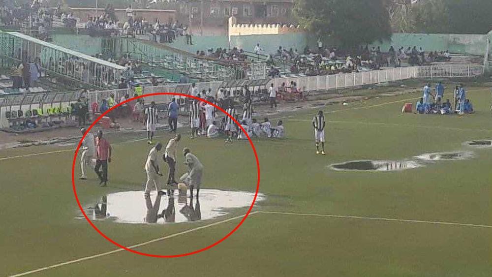 يحدث في السودان.. مسؤولو ملعب "ود مدني" يحاولون "شفط المياه" باستعمال دلو بلاستيكي وإناء