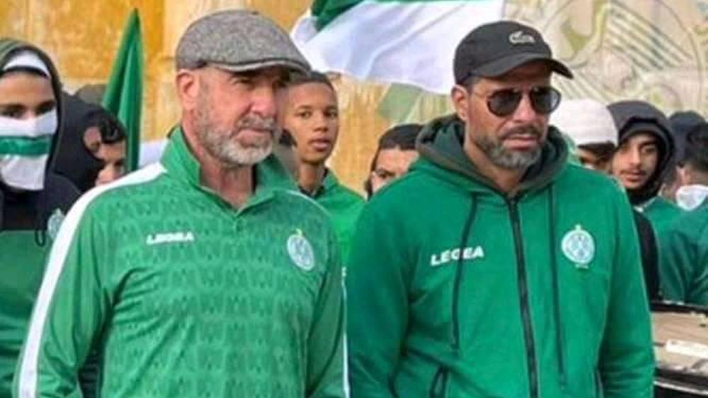 مُرتدياً قميص الرجاء ومُردّداً مع الجماهير أهازيج "الخضراء".. الأسطورة كانتونا في "عَمَل مُصوّر" مع "النسور" بالدار البيضاء