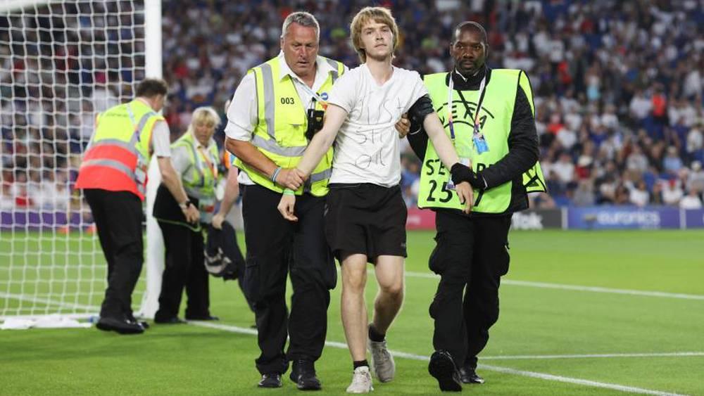 متظاهر يحاول ربط نفسه بالمرمى في مباراة إنجلترا وإسبانيا في "أمم أوروبا للسيدات" احتجاجا على مخاطر الأزمات المناخية